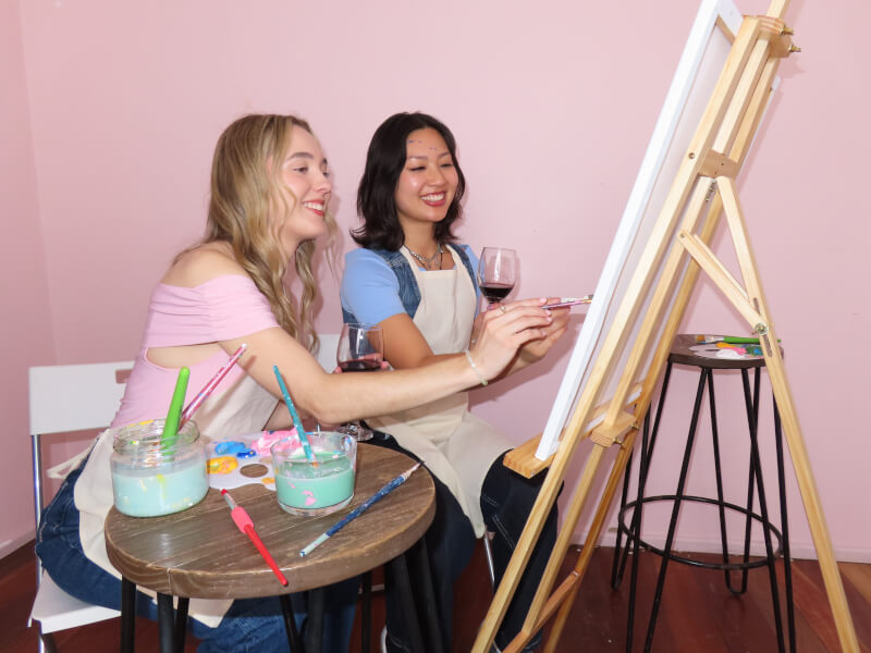 Women painting on canvases in a painting class 